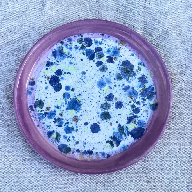 Shoreline Side Plate, a colourful plate placed on a stone surface.  