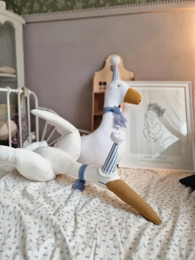 Circus Swan Hanging Decoration, a swan decoration on a bed in a child's room. 