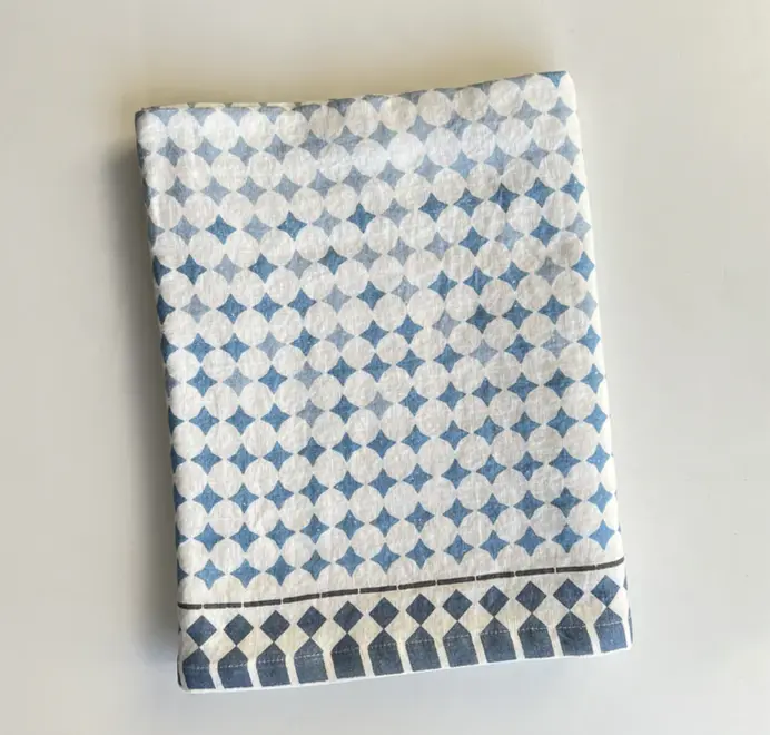 Casa Azul Tablecloth. Blue geometric Casa Azul tablecloth folded and displayed on a white background. 