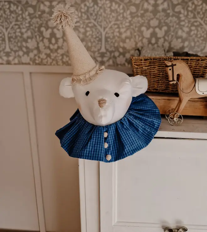 Bear Head Nursery Decoration, a bear decoration sitting against a wall in a child's decorated bedroom. 