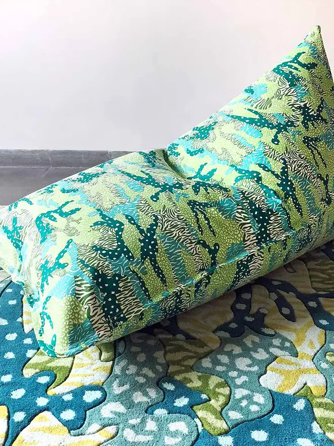 Green Big Cat Camo Bean Bag Cover, a green bean bag cover sitting on a decorated rug. 