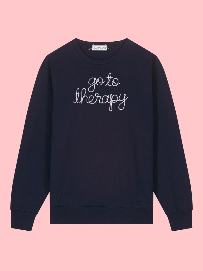 Navy sweatshirt on a pink background embroidered with go to therapy