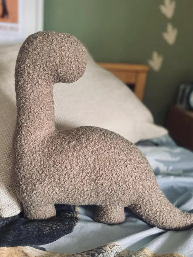 boucle dinosaur pillows. a beige diplodocus cushion.