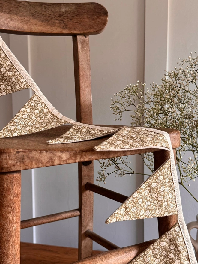 Floral Bunting. Green floral bunting on a wooden chair next to flowers