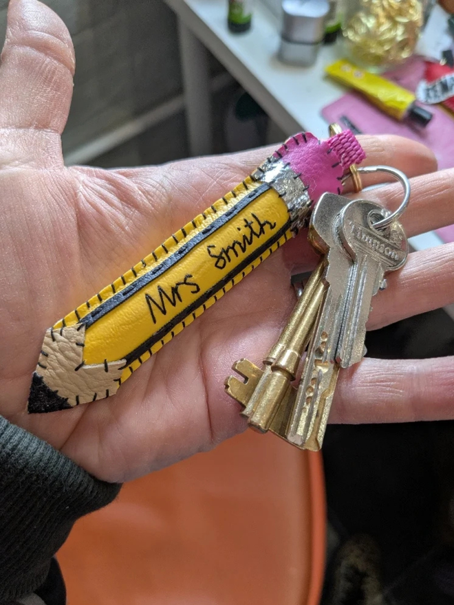 Personalised leather nostalgic pencil keyring. A pencil shaped keyring with a teachers name embroidered on the front