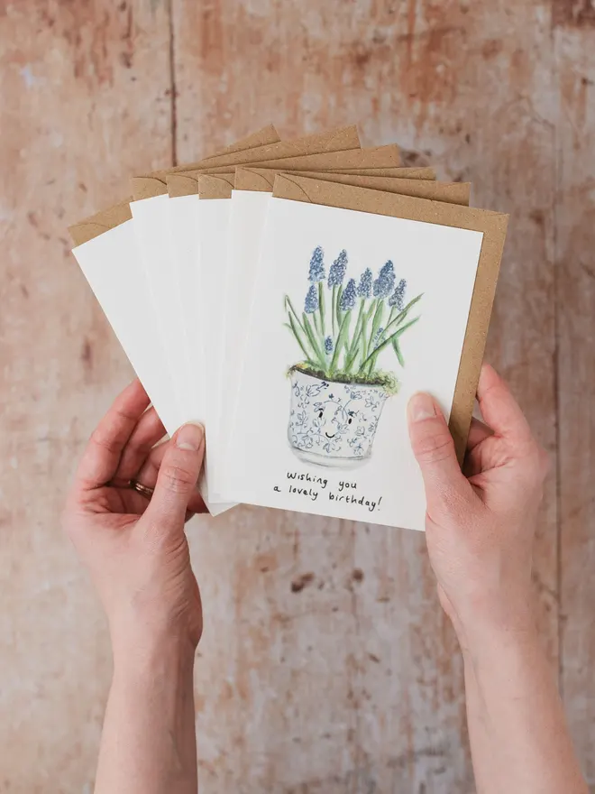 Hand holding a set of 6 Flower themed greeting cards including a spring bulb design 