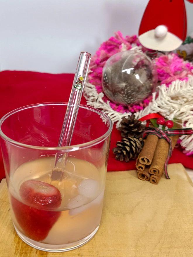 short Christmas tree straw in a drink with christmassy background