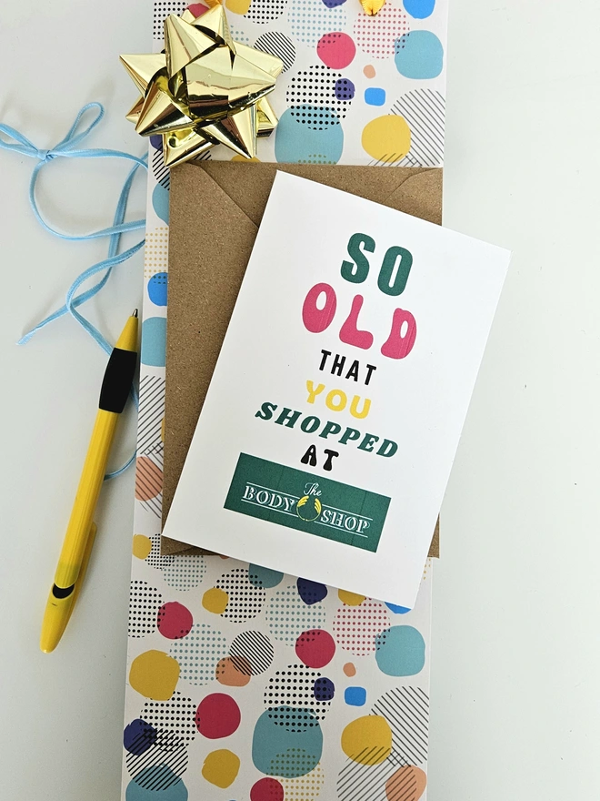 A photograph of the front of a humorous A6 greeting card illustrated using brightly coloured text and the retro shop logo. The text says so old you shopped at The Body Shop
