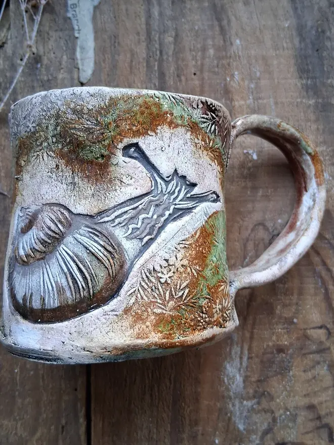 brian the snail stoneware mug. a brown mug linocut with an image of a garden snail.