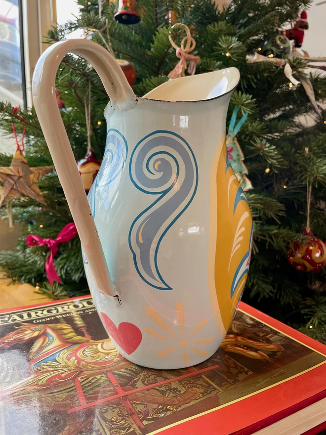 Back of blue jug shows scrollwork and a pink heart 