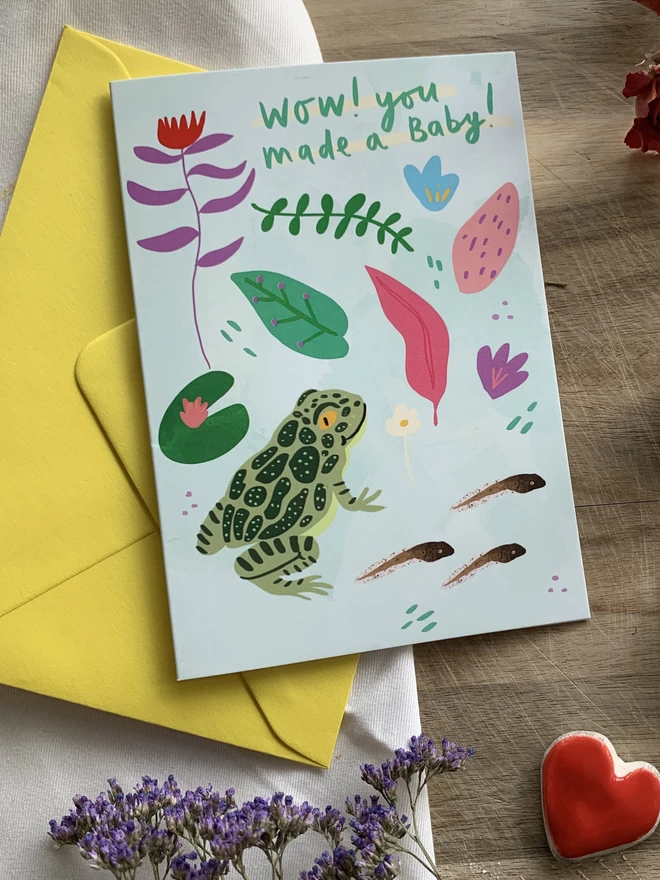 Illustrated greeting card with foliage, a frog and some tadpole on an A6 greeting card that reads - Wow! You made a baby!