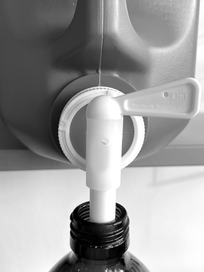 Micellar Water. A 5L tub of micellar water being used to refill a 500ml bottle.