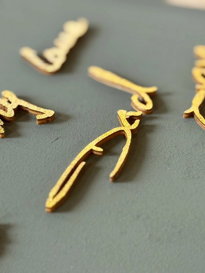 dads handwriting in gold on wood and green background by modo