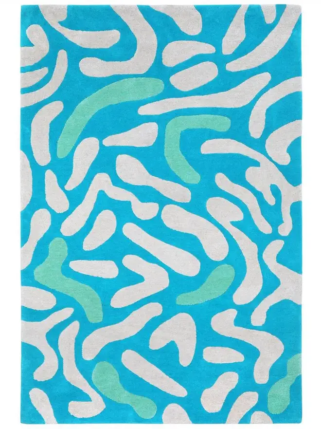 Lagoon Hand Tufted Rug, a blue rug sitting on a plain surface. 