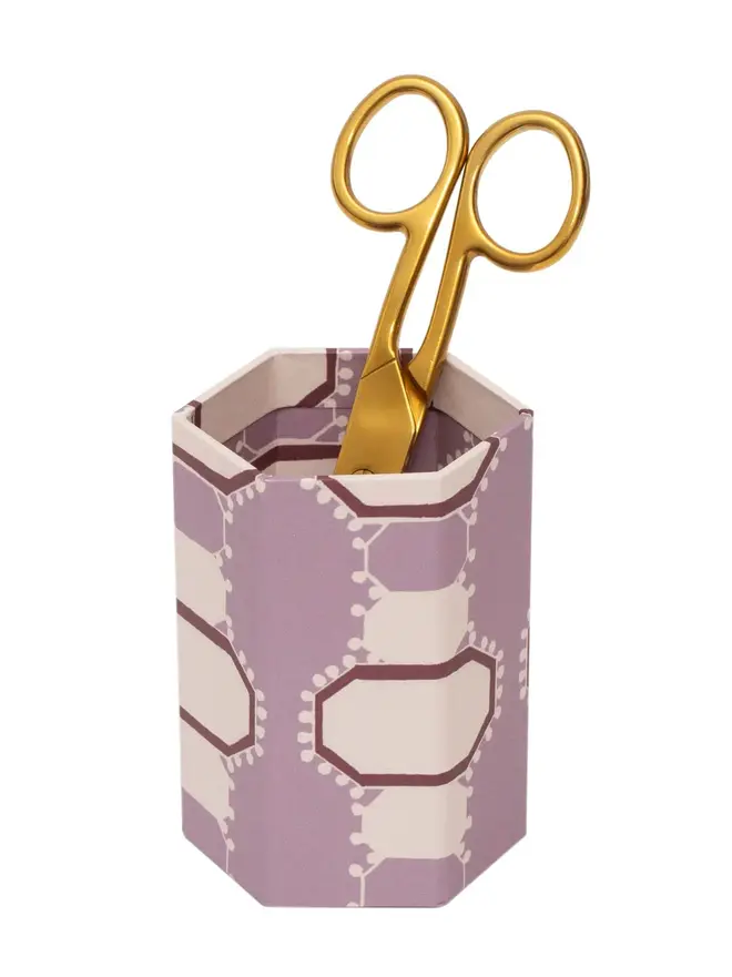 Tijan Hexagonal Brush Pot, a colourful patterned pencil pot sitting on a white surface against a plain backdrop. 