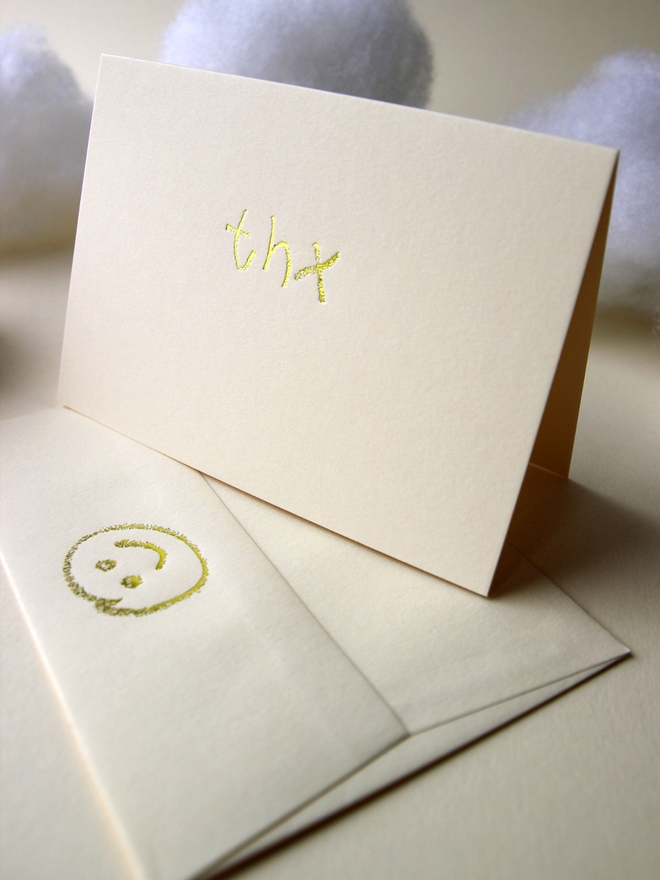 sandy coloured card with thx short for 'thank you' hand foiled in kids hand writing