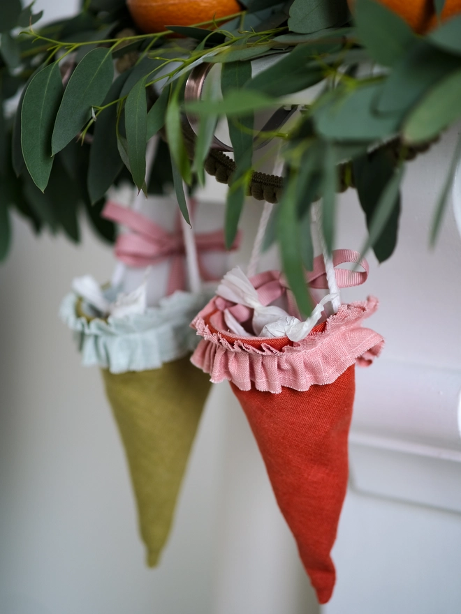 Reusable Victorian Christmas gift cones for hanging beneath festive greenery, featuring delicate ruffled trim.