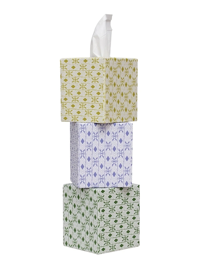 Tijan Tissue Box Cover, a group of colourful tissue boxes sitting on a white surface. 