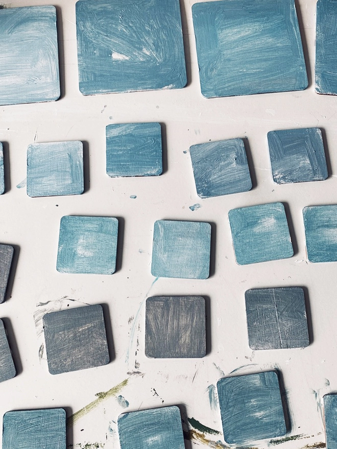 a table filled with roughly painted small boards of wood looking like blue sky