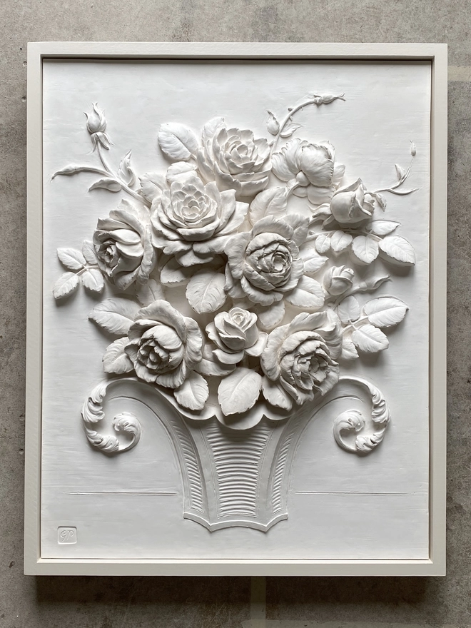 A plaster bas relief flower sculpture of a Bowl Of Roses with a painted timber frame 
