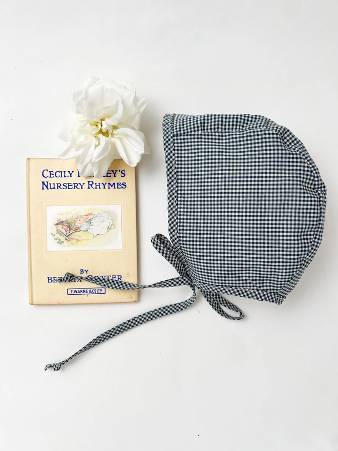 navy gingham Baby Bonnet with a vintage book