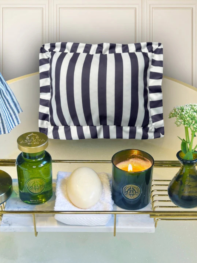 luxury frilled bath pillow. a grey and white striped frilled bath pillow affixed to a bath with candles.