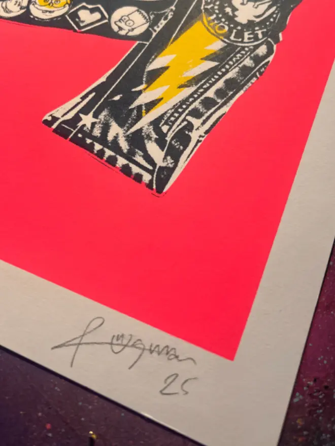 A punk leather jacket decorated with music band patches against a neon pink background.