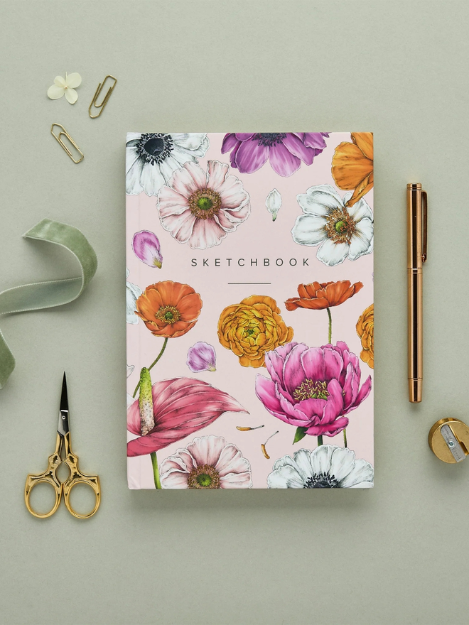 'Floral Brights' A5 Hardback Sketchbook. a pink floral sketchbook photographed on a plain grey background.