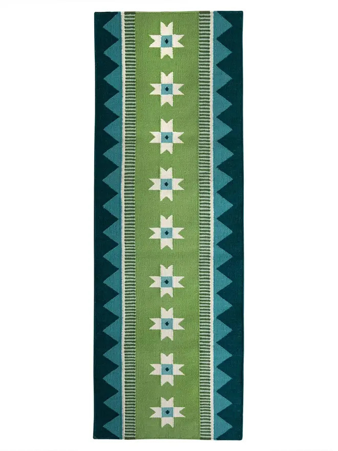 Victoria Flatweave Runner Rug, a colourful rug sitting on a white surface. 