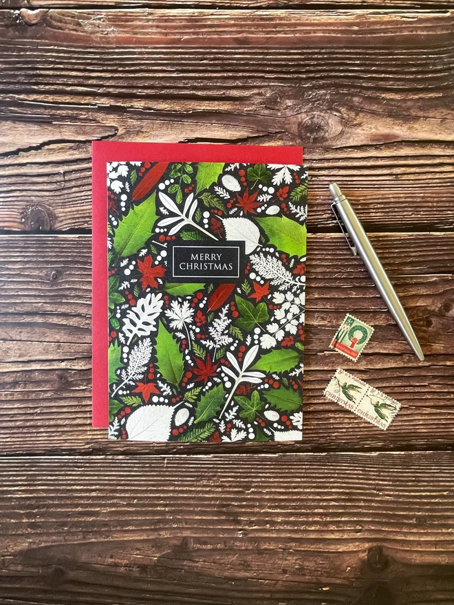 Christmas Card with Pressed Holly and Ivy Leaf Design - Wooden Background - Red Envelope - Vintage Stamps, Silver Pen
