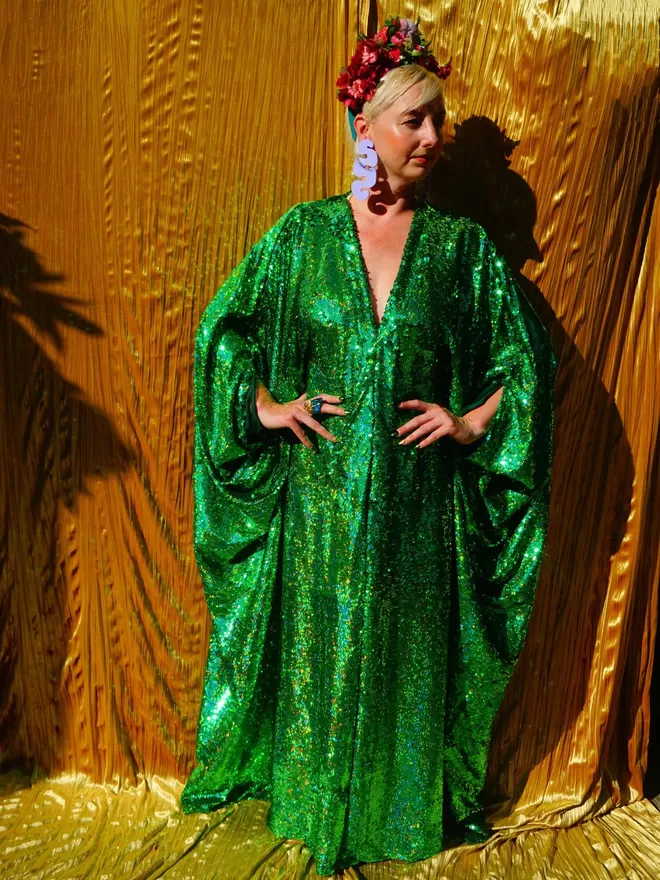 Fumbalina Green Sequin Kaftan seen on a woman standing with her hands on her hips and wearing a flower headdress.