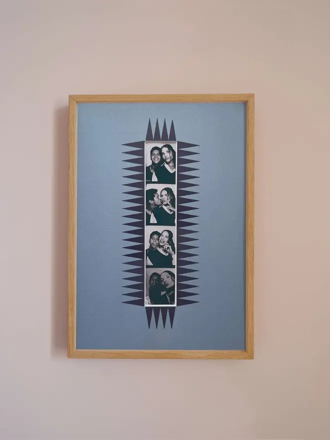 The chevron autofoto Strip Mount frame with a blue mount featuring a decorative frill border around a centered Instax Square photo, displayed on a neutral beige wall.