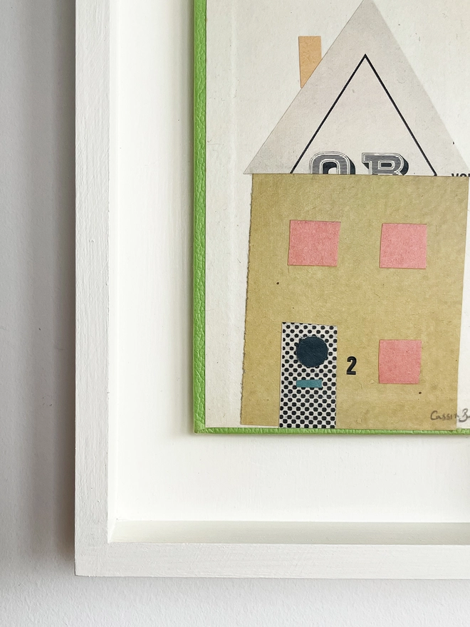 A close up view of a mustard yellow house portrait on a vintage book cover. Float mounted within a hand painted wood box frame.