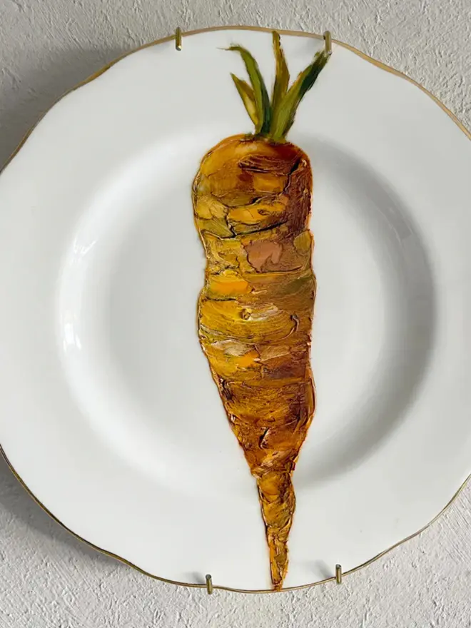 Oil Painted Carrot On A Vintage China Tea Plate, hanging on a white wall. 