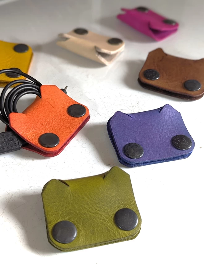 Image of leather Cat cable tidies in an assortment of colours.