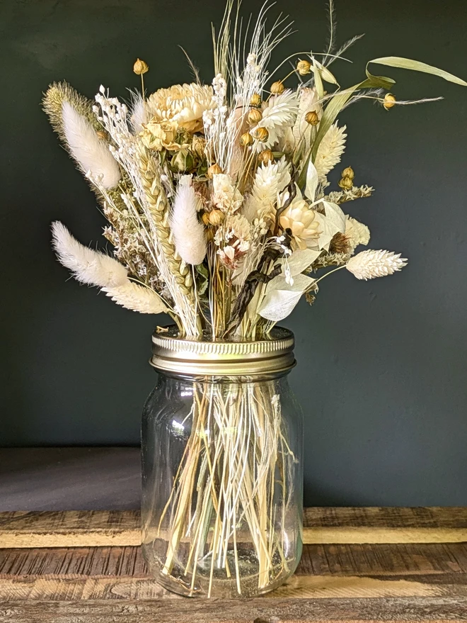 white and natural dried flowers in a glass jar
