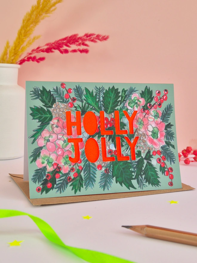 Holly and Hydrangea Christmas Card with Holly Jolly slogan and neon red paper behind it