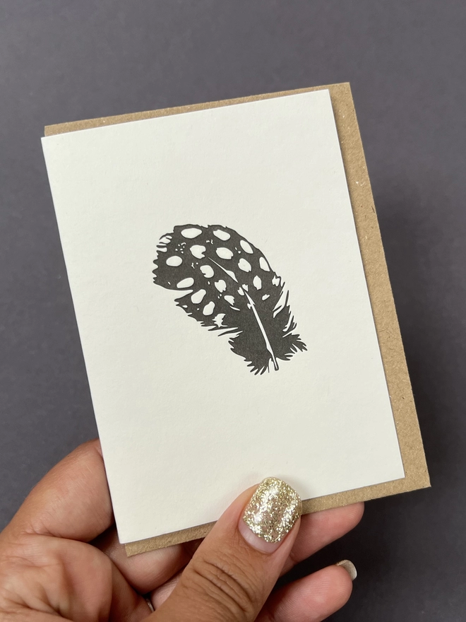 The Guinea fowl feather on the small card with envelope