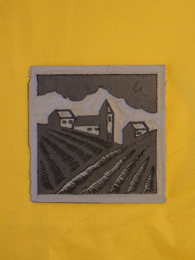 Linocut block carved to show rural farmland and houses