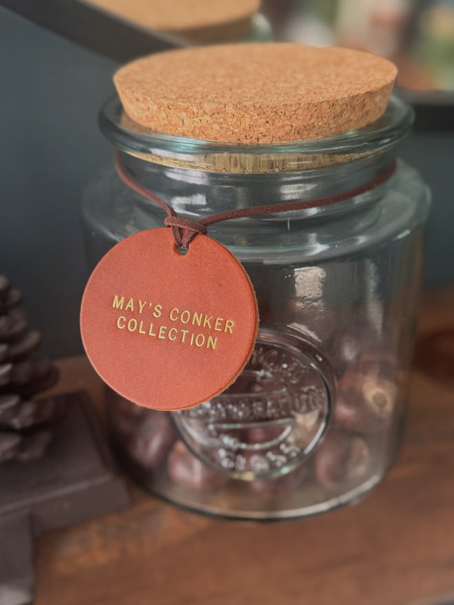 tan leather conker label on a glass jar full of conkers