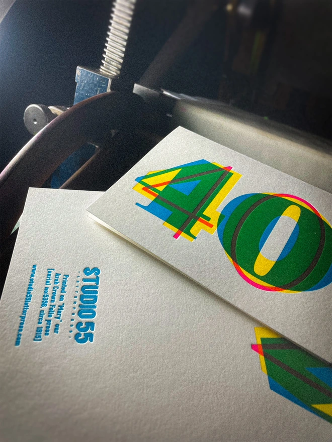 Contemporary handmade letterpress 40th birthday card featuring a bold oversized "50" in a vibrant typographic design. Printed using overlapping cyan, magenta and yellow inks to create striking secondary colours with a deep tactile letterpress impression. Individually hand printed on premium 350gsm GF Smith Colorplan card and paired with a high-quality 135gsm GF Smith Colorplan envelope in a complementary colour. Produced on a beautifully restored 1915 Arab Crown Folio press as shown here.