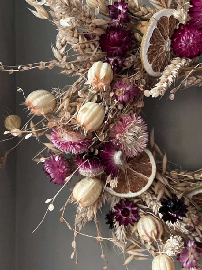 Pink Floral Dried Wreath. A pink floral wreath, hung up on a wall.