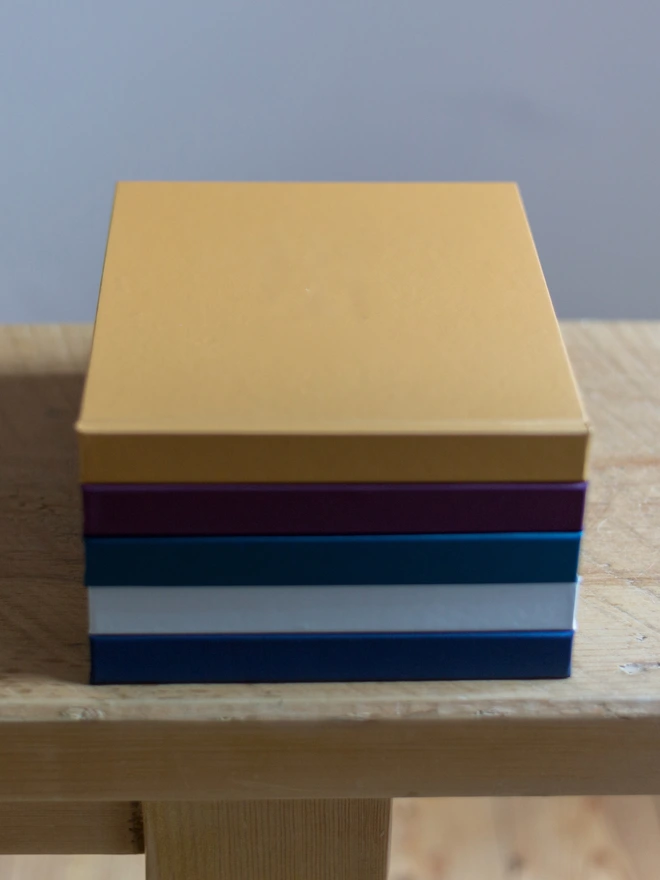 On a bench there is a pile of guest book with a yellow one on top.