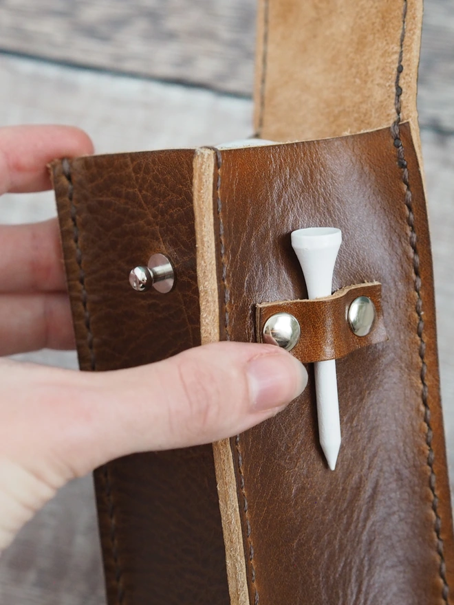 Handmade leather golf ball and tee holder. A close up of tee's held in the case.