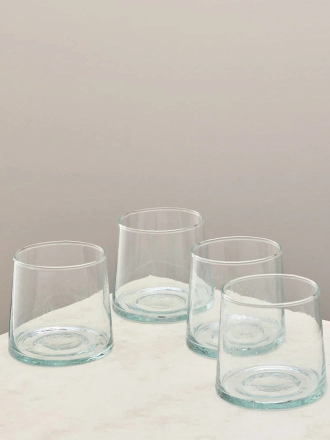 Low Glasses (Set Of 1 Or 4), a group of low glasses sitting on a white counter top against a plain backdrop. 