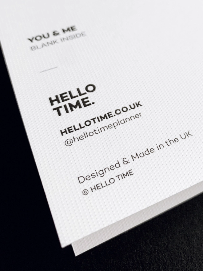 Back of greeting card showing the card texture and HELLO TIME logo