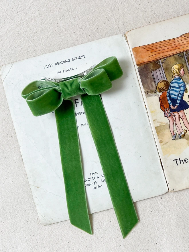 Green velvet hair bow for girls on a vintage book