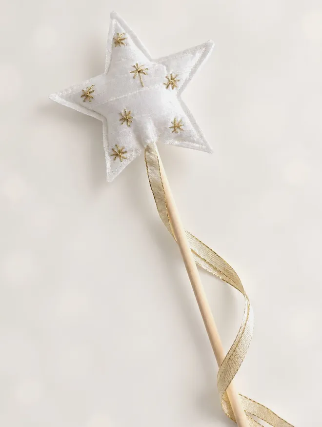 Single handmade white silk star wand with metallic gold embroidery, pale wooden handle and gold ribbon.