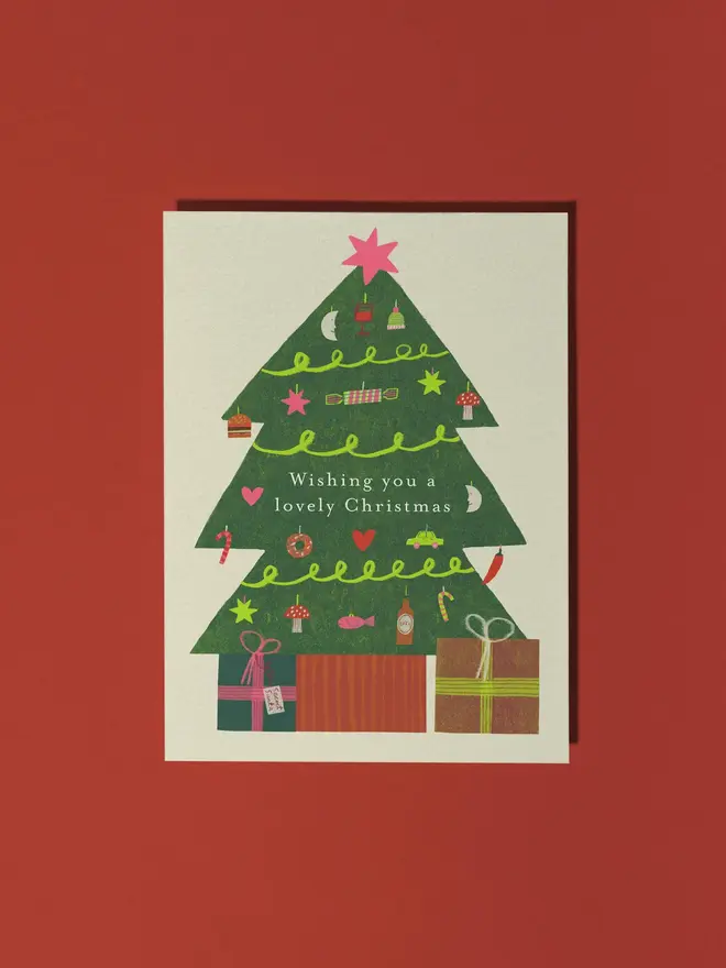 wishing you a lovely christmas illustrated card. illustrated christmas tree with gifts on a white card.