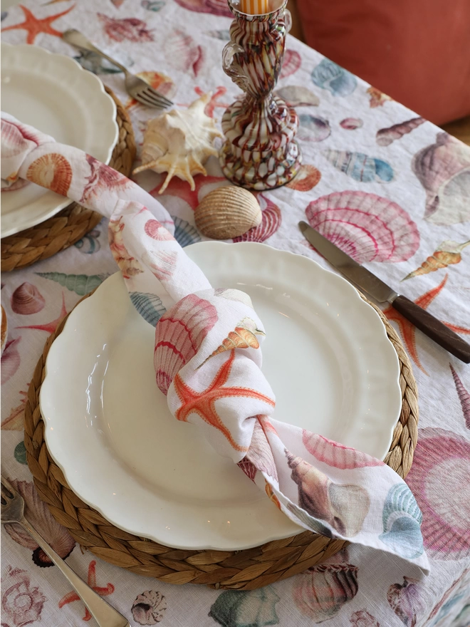 Table dressed with table linens printed with shells